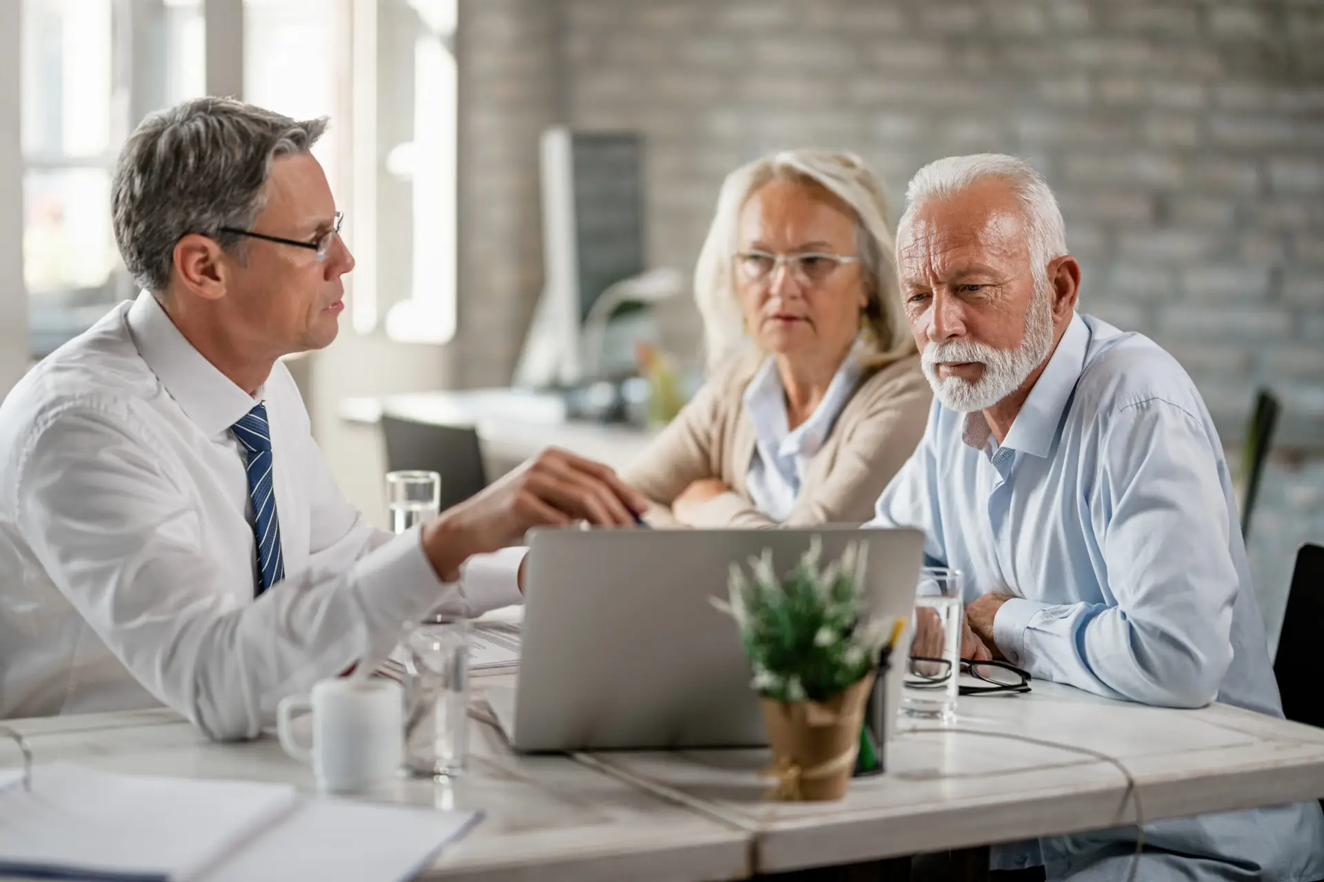 Senior couple and financial advisor using laptop on a meeting in